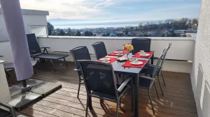 großer Balkon mit Sicht auf den Bodensee und die Schweizer Alpen. Tisch mit 6 Stühlen, 2 Liegen, Sonnenschirm und Markise