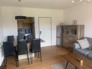 Wohnzimmer mit Esstisch, Kühl-Gefrierkombi und offener Küche