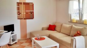 Apartment 2 Wohnzimmer mit Klimaanlage, Fernseher mit SAT-Anlage. Spiele und Bücher sind vorhanden.