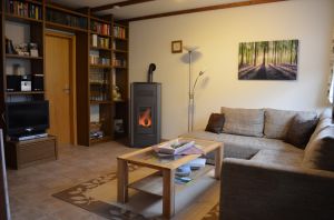 Wohnzimmer mit Pelletofen Wohnzimmer mit neuem Pelletofen und gut bestückter Bibliothek. Hier können Sie sich an Schlechtwettertagen mit Büchern, Hörbüchern oder Spielen die Zeit vertreiben.