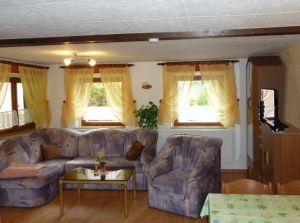 Wohnzimmer mit gemütlicher Sitzecke, Schrankwand mit HiFi Radio und Flachbildfernseher HDTV