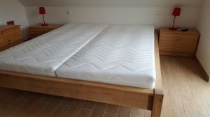 Dieses größere Schlafzimmer ist ausgestattet mit einem Doppelbett mit Tonnentaschenfederkernmatratzen, HG II und es befindet sich ein TV-Gerät im Raum.