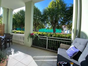 Südloggia mit schönem Ambiete liebevoll dekoriert und möbliert mit XL-Strandkorb und schicker Rattan-Essgruppe für 4 Pers.