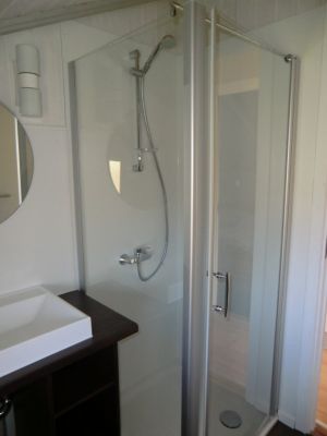 Die Dusche hat einen ebenerdigen Einstieg und eine große Türe.