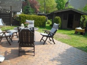 Terrasse mit Sitzgruppe und kleiner eingewachsener Garten.