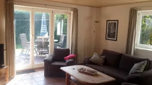 Wohnzimmer mit Couch und 2 Sesseln.
Blick in Richtung Terrassentür