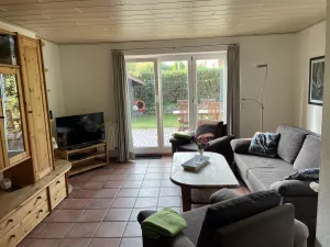 Sitzgarnitur mit bequemer Schlafcouch. Zugang zu Garten und Terrasse.