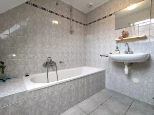 Badezimmer mit Duschhalterung, Waschbecken und WC