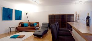 Bettcouch, Liege zum Chillen, Wohnzimmerschrank, Barhocker und Essbereich zur offenen Küche.