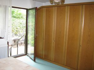 Großzügiges Schlafzimmer mit Kleiderschrank und Zugang nach Außen