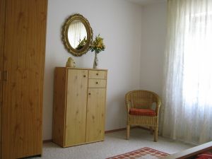 großzügiges Schlafzimmer mit Schrank, Kommode und Sitzecke