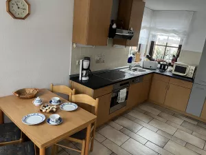 Voll ausgestattete Küche mit Essplatz und Zugang zum Balkon