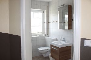 Bad mit Zugang zur Sauna. Waschmaschine befindet sich neben der Dusche.