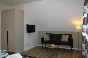 Schlafzimmer mit Doppelbett, Fernseher und Leseecke