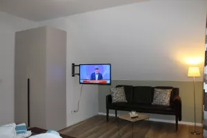 Schlafzimmer mit Doppelbett, Fernseher und Leseecke