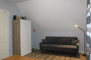 Schlafzimmer mit Doppelbett, großer Kleiderschrank und Relaxsofa