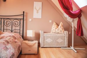 Schlafzimmer im OG Schlafzimmer 3 im Obergeschoß
Das Schlafzimmer ist mit einem 1,40 Meter Bett, Nachtschränckchen, Leselampen, einem Kleiderständer, Ventilator und einer kleinen Kommode ausgestattet.