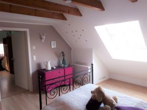 Schlafzimmer im OG Schlafzimmer 3 im Obergeschoß
Das Schlafzimmer ist mit einem 1,40 Meter Bett, Nachtschränckchen, Leselampen, einem Kleiderständer, Ventilator und einer kleinen Kommode ausgestattet.