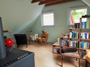 Wohnzimmer im OG Wohnzimmer im Obergeschoß
Das Wohnzimmer ist mit Kaminofen und Lese-Ecke eingerichtet.
Es ist einiges an Büchern, Spielen, DVD ´s und CD´s für Groß und Klein vorhanden.
Auch verfügt es über ein Schlafsofa auf dem zusätzlich jemand schlafen kann sowie einer Ottomane.
Natürlich gibt es hier auch eine Ecke für die vierbeinigen Gäste.
Auch hier ist ein Ventilator vorhanden.