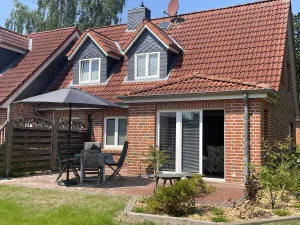 Terrasse mit Sitzgelegenheiten und Sonnenschirm.
Eine Sonnenliege ist ebenfalls vorhanden.