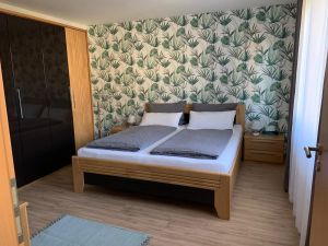 Schlafzimmer, Bett inKomforthöhe Im Dezember 2020 neu tapeziert, großer Kleiderschrank und Kommode.