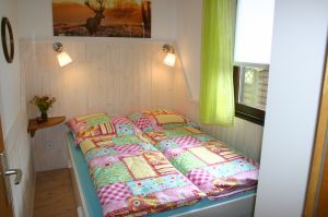 Ferienhaus EifelNest Schlafzimmer 2 Hier grüßt Sie das "Hirschchen":
1 Doppelbett (1,40m x 2m) mit Bettschublade, 1 geräumiger Kleiderschrank, 1 Bücherregal und 1 Nachtkonsölchen.