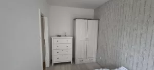 Schlafzimmer renoviert und neuer Boden mit bequemen Bett, Nachttisch, Kleiderschrank und Kommode