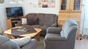 Wohnzimmer mit bequemer Couchgarnitur,
SAT-TV, Tisch, Vitrine und Sekretär