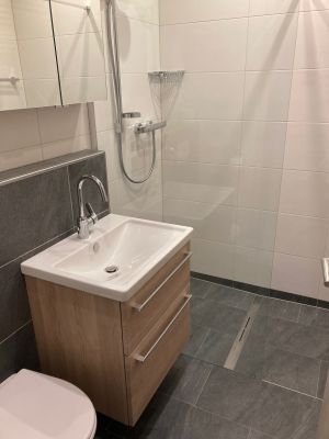 Duschbad mit Hänge-WC, Waschtisch, Unterschrank, großer bodentiefer Dusche und Handtuchheizkörper