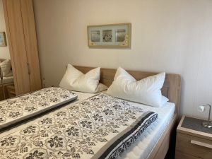 Das Elternschlafzimmer mit Doppelbett in Komforthöhe und geräumigem Kleiderschrank.
