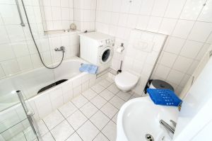 Geräumiges Badezimmer mit Wanne und Waschmaschine.