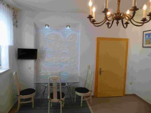 Ferienzimmer 1 mit Essplatz, TV,
und farbigen Wandrelief