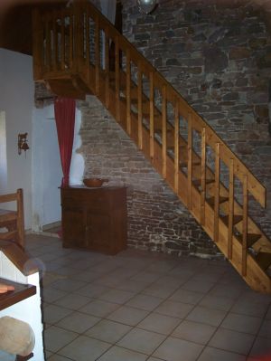 Über die Holztreppe gelangt man zu den Schlafräumen und dem Bad.