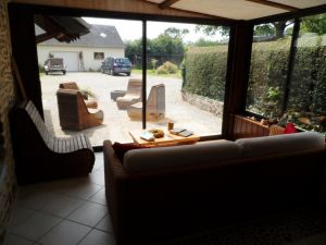 Wintergarten und Außensitzplatz Der Wintergarten ist ausgestattet mit Rattancouch und kleinem Esstisch. Im Außenbereich ein weitere Sitzbereich und Blick auf Garten und unsere Garage.