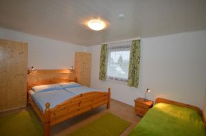 Das Schlafzimmer mit einem Doppelbett und einem Einzelbett.