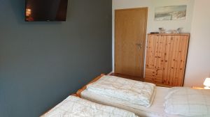 Schlafzimmer mit Doppelbett und Fernseher