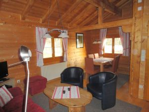 Eßecke Haus 15 Für die Mahlzeiten stehen im Eßbereich ein großer Tisch und 5 Stühle bereit.
Im oberen Teil ist die offene Holzkonstruktion des Daches zu sehen.