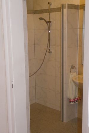 Die Dusche ist barrierefrei. Für kleine Kinder gibt es eine kleine Wanne.