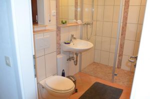 Modernes Bad mit ebenerdiger Dusche, WC und Badheizung im Souterrain