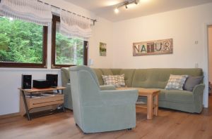 Das helle Wohnzimmer verfügt über eine große gemütliche Sitzecke