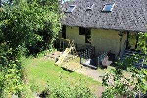 Der Spielplatz liegt hinter dem Haus.