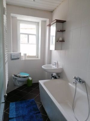 Im Badezimmer befindet sich eine Wanne mit Dusche