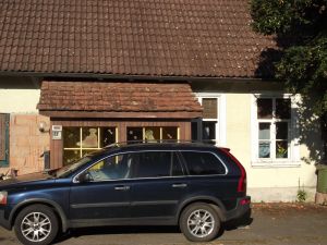 Frontansicht der Wohnung mit PKW-Stellplatz und separaten Eingangsbereich (Vorbau).