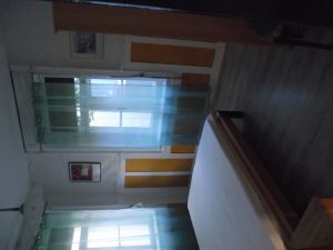 Schlafzimmer mit Schrank, Regal, Nachtisch und Bett mit Nachttischlampe.