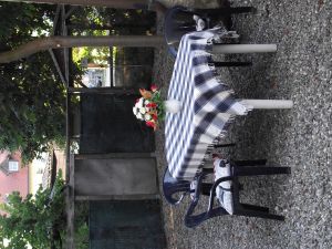 Eine kleine, gekieste (Hundefreundlich eingezäunte) Terrasse mit Tisch und Stühlen.
