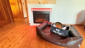 Das gemütliche Wohnzimmer ist mit einem großem hochwertigen Ecksofa, großen Smart-TV, Schreibtisch, Leselampe, Elektrokamin, und einem Hundebett ausgestattet.