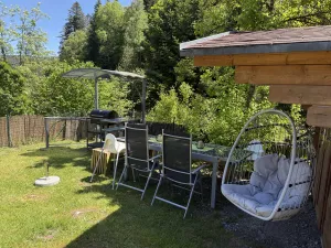 Ihr Garten ist mit zwei Esstischgruppe, Hängesessel, Sonnenschirme, BBQ Holzkohlengrill ausgestattet.