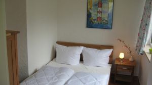Schlafzimmer mit TV Hier sehen Sie das kleine Schlafzimmer mit dem 140er Bett, welches auch mit einem TV ausgestattet ist. Das Haus hat insgesamt 3 Schlafzimmer. 2 x mit 180er Doppelbetten im Souterrain und 1 x in der Paterre mit einem 140er Bett. Es ist also Platz für maximal 6 Personen. Bedenken Sie dann aber, dass nur 1 Duschbad zur Verfügung steht.