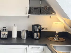 Kaffemaschine, Wasserkocher, Toaster. Eine Mikrowelle befindet sich im Hängeschrank