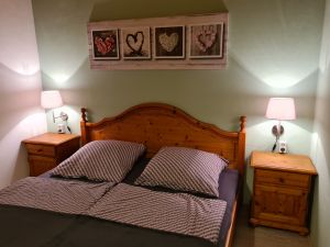 Schlafzimmer 1/ Elternschlafzimmer Schlafzimmer mit Doppelbett, zweitürigem Schrank, zwei Nachttischen und Garderobe. Zum Schlafzimmer gehört eine separate Toilette mit Waschbecken.